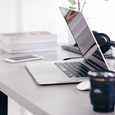 ordinateur sur une table avec des boissons et un téléphone et des papiers